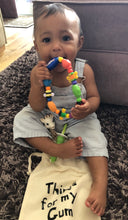 Load image into Gallery viewer, A cute baby holding a teething toy that she has taken out of the canvas bag with things for my gum printed on the front