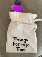 Load image into Gallery viewer, A canvas drawstring bag with Things for my tum printed on the front and a baby food pouch poking out of the top.